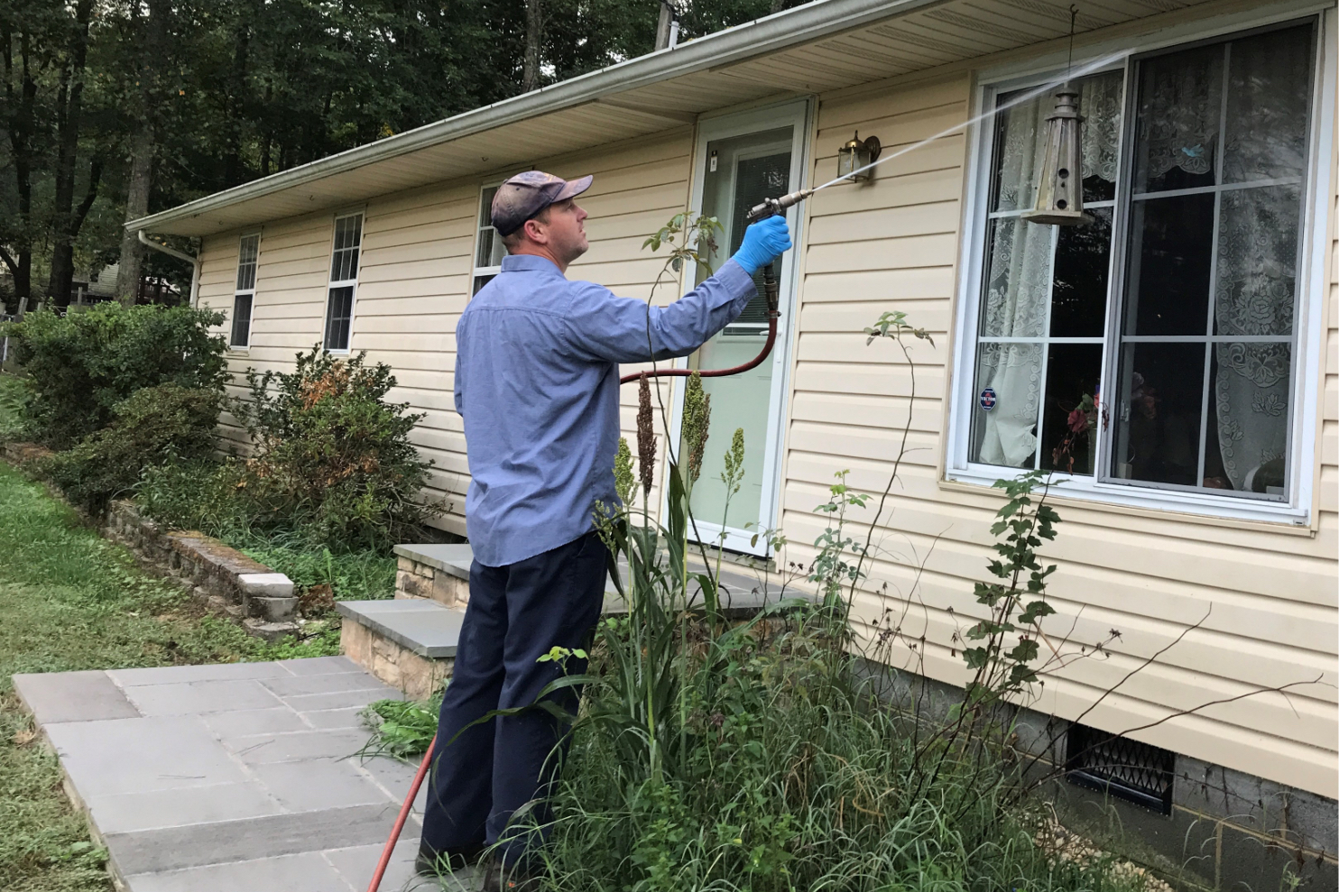 Photo of a technician treating a house exterior