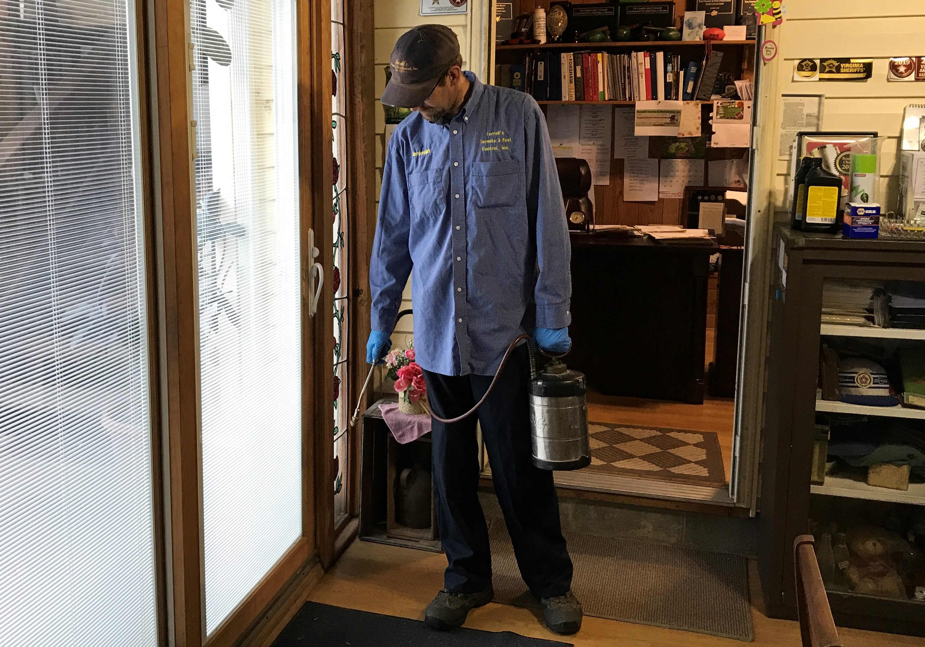 Pest control technician spraying for insects